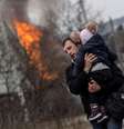 Homem e criança fogem de bombardeios em Irpin, na Ucrânia   Foto: Carlos Barria / Reuters