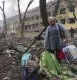 Uma mulher caminha do lado de fora de uma maternidade atingida por um bombardeio russo em Mariupol, Ucrânia  Foto: Evgeniy Maloletka