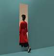 Mulher em um vestido vermelho passando por um buraco em uma parede azul  Foto: Getty Images / BBC News Brasil
