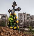 Cova de civis mortos durante o conflito próximo de prédios em Mariupol  Foto: Reuters