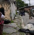 Moradores e policiais ao lado de um corpo coberto após operação policial que deixou 23 mortos na Vila Cruzeiro, Rio de Janeiro  Foto: DW / Deutsche Welle