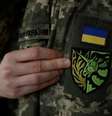 Antonina Romanova, 37, mostra a insígnia de unicórnio em seu uniforme simbolizando a comunidade LGBT+, no dia de sua partida para a linha de frente, em Kiev, Ucrânia  Foto: Reuters