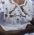 Imagem mostra dois corpos negros abraçados de costas, sendo um deles de uma praticante da umbanda usando vestes brancas, típicas da religião  Foto: Imagem: Reprodução / Agência Brasil / Alma Preta