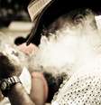 Imagem mostra um homem soltando fumaça de cachimbo.  Foto: Imagem: Rennan Peixe / Alma Preta