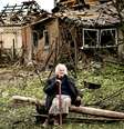 Uma mulher se senta em frente a duas casas que foram demolidas por um ataque de míssil, que matou outra mulher, em Druzhkivka, Donetsk  Foto: Getty Images / BBC News Brasil