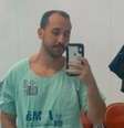 Giovanni está na frente de um espelho. Ele segura um celular e usa um uniforme de hospital  Foto: Reprodução/Redes sociais / Alma Preta