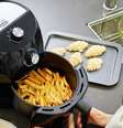 Mulher usando air fryer para fazer batata frita  Foto: Getty Images / BBC News Brasil