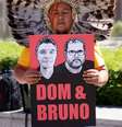 Indígena brasileiro segura cartaz com os rostos do indigenista Bruno Pereira e do jornalista britânico Dom Phillips durante manifestação em Bruxelas  Foto: DW / Deutsche Welle