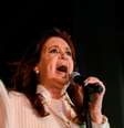 Kirchner gesticula enquanto fala no microfone, em evento à noite  Foto: Reuters / BBC News Brasil