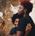 Imagem mostra mulher negra abraçada com a filha.  Foto: Imagem: @eyeforebony/Unsplash / Alma Preta