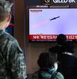 Pessoas assistem a uma reportagem na TV que mostra a Coreia do Norte disparando mísseis balísticos no mar, em Seul, na Coreia do Sul, em 2 de novembro de 2022  Foto: YONHAP/REUTERS / BBC News Brasil