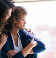 Imagem mostra pessoas negras, duas mulheres que se consolam.  Foto: Imagem: Getty Images / Alma Preta