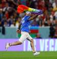 Torcedor invade campo com bandeira LGBTQIA+ e camisa pedindo respeito às mulheres iranianas e para salvarem a Ucrânia  Foto: Reuters