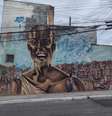 Grafite do grupo OPINI, na Rua Vitório Azzalin, em São Mateus, traz Tia Cida alegre sobre as favelas do bairro @Matheus Oliveira/Agência Mural  Foto: Agência Mural