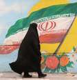 Mulher caminha em Terrã ante grafite com bandeira do Irã   Foto: Reuters