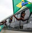 ônibus com apoiadores de Bolsonaro e bandeira do Brasil  Foto: Reuters / BBC News Brasil