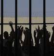 Imagem mostra internos com mãos erguidas atrás de grade de uma penitenciária.  Foto: Imagem: Wilson Dias/Agência Brasil / Alma Preta
