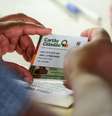 Beneficiário do programa Devolve ICMS, do Rio Grande do Sul, recebe seu cartão com o crédito para consumo  Foto: Gustavo Mansur/Palácio Piratini / BBC News Brasil
