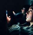 Mulher mexendo em celular em quarto escuro  Foto: Getty Images / BBC News Brasil