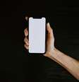 Uma mão segurando um celular com a tela em branco.  Foto: Kelly Sikkema via Unsplash