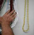 Imagem mostra a mão de uma pessoa tocando adereços de religião de matriz africana para ilustrar crime de racismo  Foto: Imagem: Tânia Rego/Agência Brasil / Alma Preta