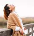 Mulher feliz com o rosto virado para o Sol sobre uma ponte  Foto: Getty Images / BBC News Brasil