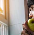 Imagem ilustrativa de uma menina comendo uma fruta  Foto: Khamkor/ Unsplash