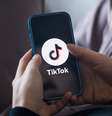 Pessoa de costas usando celular, que mostra logo do TikTok  Foto: Getty Images / BBC News Brasil