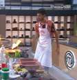 Endrik tenta ajudar Camila, que botou fogo na cozinha do MasterChef  Foto: Reprodução/Band