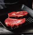 Mãos de homem segurando grelha com carne crua  Foto: Getty Images / BBC News Brasil