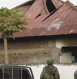Agentes das forças de segurança de Uganda em frente à escola secundária Lhubiriha, em Mpondwe  Foto: Getty Images / BBC News Brasil