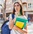 Na imagem uma jovem estudante, com cadernos na mão.  Foto: AaronAmat / iStock