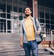 Imagem mostra estudante homem em frente a uma faculdade.  Foto: max-kegfire / iStock