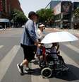 Pedestres atravessam a rua em um dia quente com alerta laranja de onda de calor em Pequim, na China (16/06/2023)  Foto: REUTERS/Florence Lo/File Photo