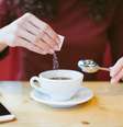 Mulher usa adoçante no café; aspartame foi classificado como potencialmente cancerígeno  Foto: iStock