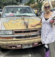 Pinky ao lado de sua caminhonete decorada com gliter usada para salvar pessoas no incêndio  Foto: BBC News Brasil