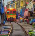 Estrada de ferro tailandesa com um trem local funciona através do mercado de Mae Klong na província de Samut Songkhram, Tailândia.   Foto: tampatra / iStock