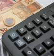 Imagem mostra dinheiro e calculadora.   Foto: Agência Brasil 