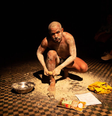 Foto mostra uma fotografia da Série “Até os filhos do urubu nascem brancos”, de Waleff Dias. Na imagem, há um homem abaixado, esfregando farinha em seu corpo já coberto pela textura esbranquiçada.  Foto: Alma Preta
