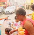 Frame da reportagem "Contos verdade com Tialila" mostra a ativista Rita Santa Rita distribuindo jornal do Grupo de Mulheres do Alto das Pombas (GRUMAP), em Salvador (Foto: Reprodução)  Foto: Alma Preta