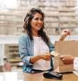 Cliente feliz pagando com um cartão de crédito em uma loja de cerâmica   Foto: Foto: Istock
