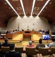 Imagem mostra uma sessão no Supremo Tribunal Federal, uma grande sala com os ministros sentados no centro e outros espectadores em sua volta.  Foto: Alma Preta