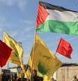 Membros do Harakat Hezbollah al Nujaba seguram uma bandeira palestina e outras bandeiras durante um protesto em solidariedade aos palestinos em Gaza  Foto: REUTERS/Ahmed Saad