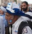 Uma mulher muçulmana e um homem com a bandeira de Israel na bochecha discutem frente a frente   Foto: Getty Images / BBC News Brasil