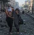 Homem e mulher caminham em escombros  Foto: EPA / BBC News Brasil