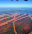 Fotografia aérea da baía de Bombetoka, onde o rio passa para chegar até o mar — a grande quantidade de sedimentos pode ser vista em seu início, "enferrujando" o fluxo fluvial (Imagem: oledoe/CC-BY-2.0)  Foto: Canaltech