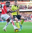 Saka (do Arsenal, de vermelho) recebe a marcação de  Charlie Taylor , do Burnley –  Foto:   Glyn Kirk/AFP via Getty Images / Jogada10