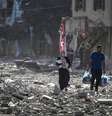 Palestinos caminham em meio a destroços deixados por bombardeio israelense na Cidade de Gaza  Foto: ANSA / Ansa - Brasil