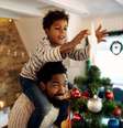 Imagem meramente ilustra mostra pai e filho decorando árvore de natal  Foto: Drazen Zigic / iStock