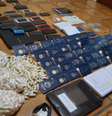 No local foram apreendidos dezenas de passaportes, anotações do tráfico, celulares, cartões de banco e cápsulas contendo material branco, aparentando se tratar de cocaína  Foto: Divulgação/SSP